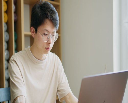A person working comfortably on a laptop in a well-lit modern home office